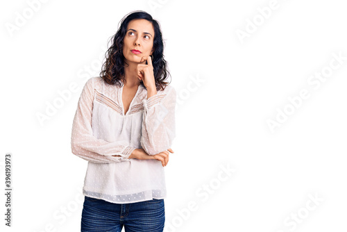 Young beautiful hispanic woman wearing casual clothes serious face thinking about question with hand on chin, thoughtful about confusing idea