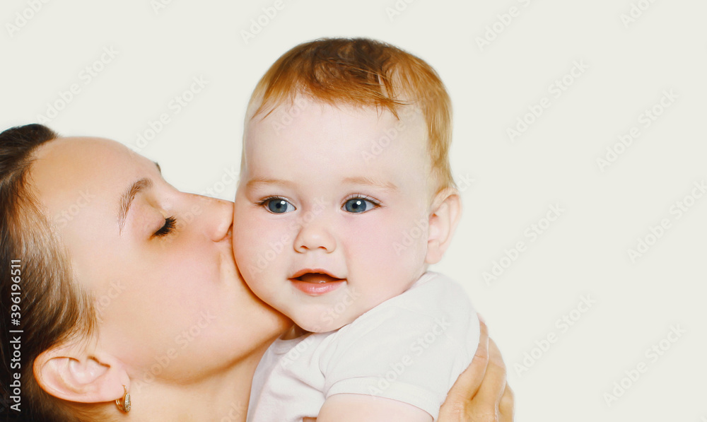 Portrait close up of happy mother kissing her cute baby over a white background Portrait close up of happy mother kissing her cute baby over a white background