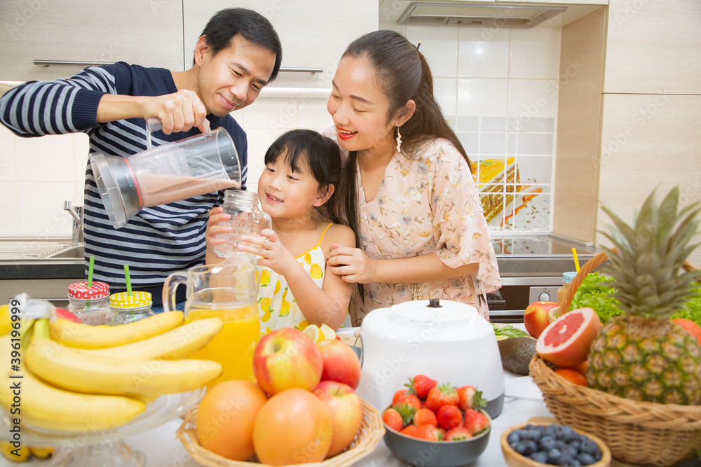 Happy asian family mother and her daughter enjoy prepare freshly squeezed fruits with vegetables for making smoothies for breakfast together in the kitchen. diet and Health concept.
