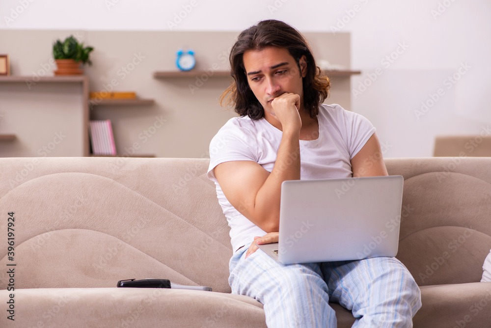 Young lazy man in oversleeping concept at home Young lazy man in oversleeping concept at home