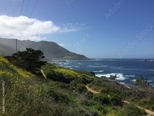 A picturesque view of the deep blue Pacific Ocean with mountains and hills along the coastal shore in the Monterrey area along Pacific Coast Highway 1 in California, USA photo