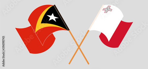 Crossed and waving flags of East Timor and Malta