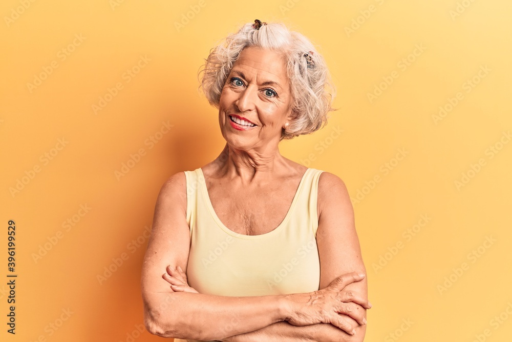 Senior grey-haired woman wearing casual clothes happy face smiling with crossed arms looking at the camera. positive person. Senior grey-haired woman wearing casual clothes happy face smiling with crossed arms looking at the camera. positive person.