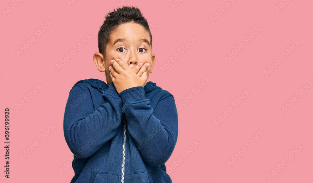 Little boy hispanic kid wearing casual sporty jacket shocked covering mouth with hands for mistake. secret concept. Little boy hispanic kid wearing casual sporty jacket shocked covering mouth with hands for mistake. secret concept.