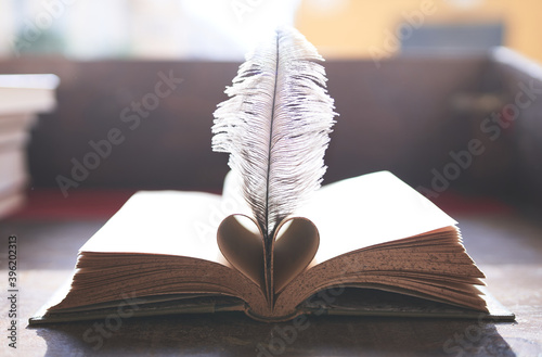фотографія Book forming a heart with a feather