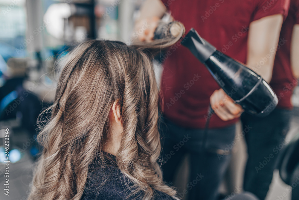 Naklejka premium Beautiful hairstyle of woman after dyeing hair and making highlights in hair salon.