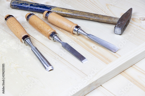 Chisels on a wooden background. Assortment of chisels of wood for carpentry. A set of tools for wood processing