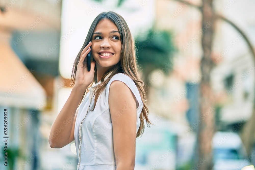 Beautiful latin teenager girl smiling happy talking on the smartphone at the city. Beautiful latin teenager girl smiling happy talking on the smartphone at the city.