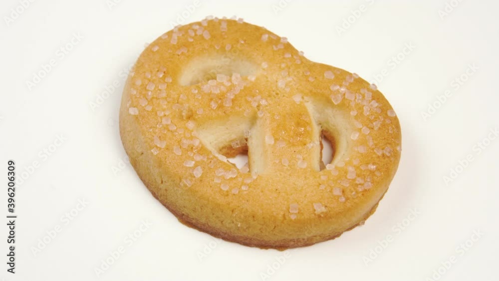 Single butter cookie with sugar on a white plate surface. Macro shot. Shortbread cookies close up. Rotation Single butter cookie with sugar on a white plate surface. Macro shot. Shortbread cookies close up. Rotation