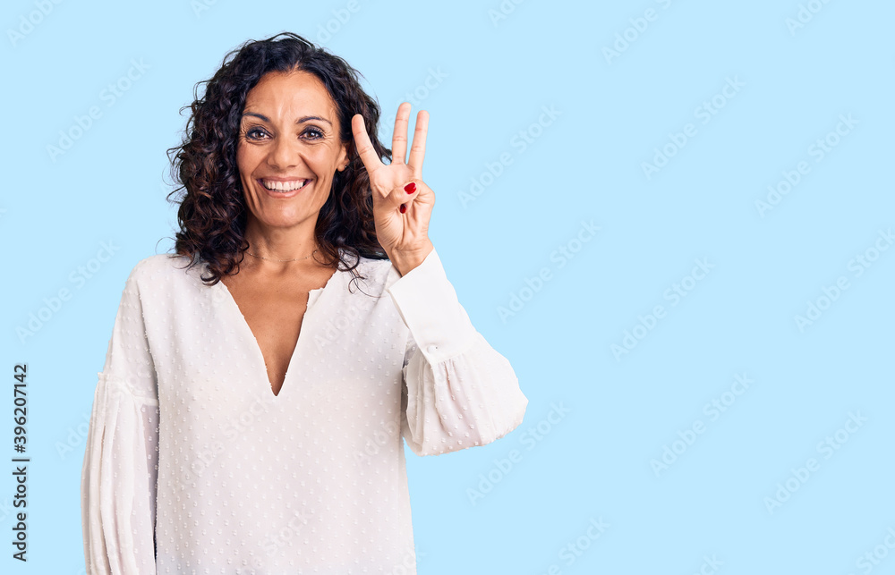 Middle age beautiful woman wearing casual sweater showing and pointing up with fingers number three while smiling confident and happy.
