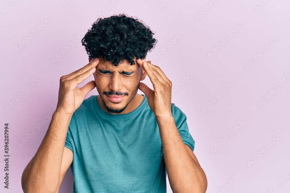 Young arab handsome man wearing casual clothes with hand on head for pain in head because stress. suffering migraine. Young arab handsome man wearing casual clothes with hand on head for pain in head because stress. suffering migraine.