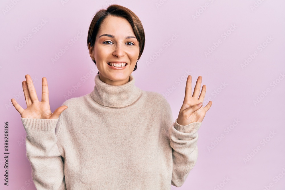 Young brunette woman with short hair wearing casual winter sweater showing and pointing up with fingers number nine while smiling confident and happy. Young brunette woman with short hair wearing casual winter sweater showing and pointing up with fingers number nine while smiling confident and happy.