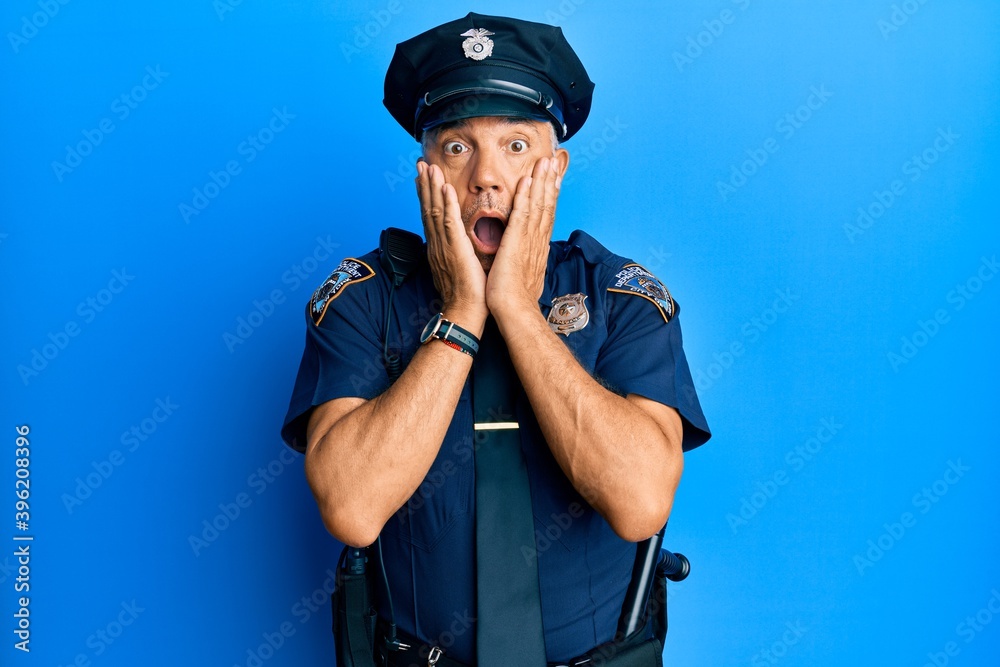 Handsome middle age mature man wearing police uniform afraid and shocked, surprise and amazed expression with hands on face Handsome middle age mature man wearing police uniform afraid and shocked, surprise and amazed expression with hands on face