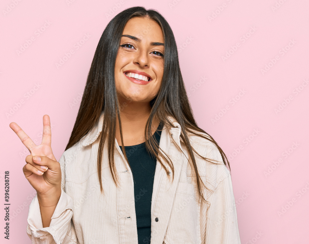 Beautiful hispanic woman wearing casual clothes smiling with happy face winking at the camera doing victory sign. number two. Beautiful hispanic woman wearing casual clothes smiling with happy face winking at the camera doing victory sign. number two.