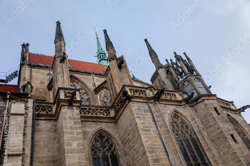 Low angle view at a part of Medieval stone St. Bartholomew´s Church in autumn day, arched windows, chimeras and gargoyles, Gothic Cathedral, Kolin, Central Bohemia, Czech republic photo