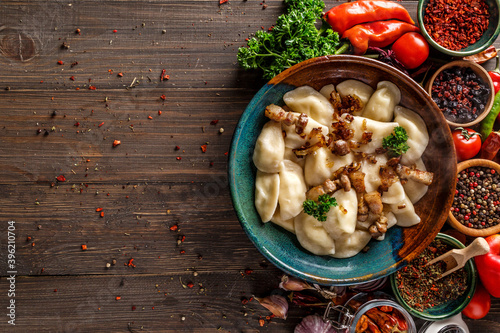 Pierogi or pyrohy, varenyky, vareniki, dumplings served with caramelized salted onion in bowl on wooden table - traditional Ukrainian food photo