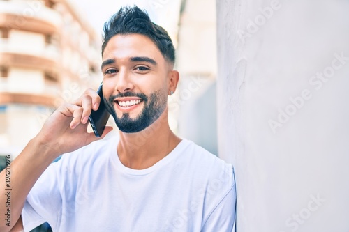 Young arab man with serious expression talking on the smartphone at the city.