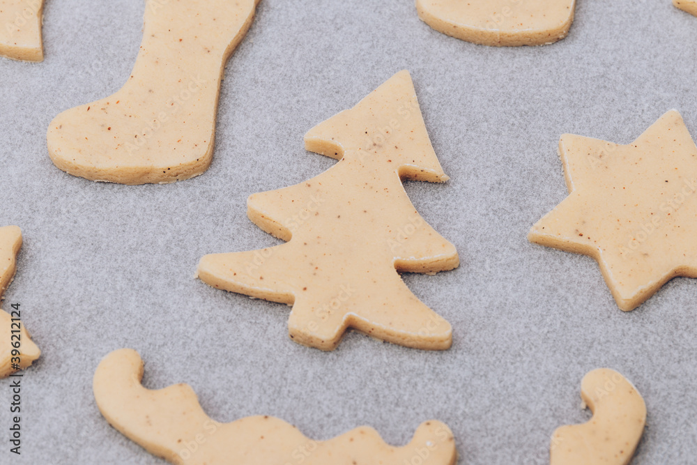 Raw gingerbread cookies on the white baking sheet.