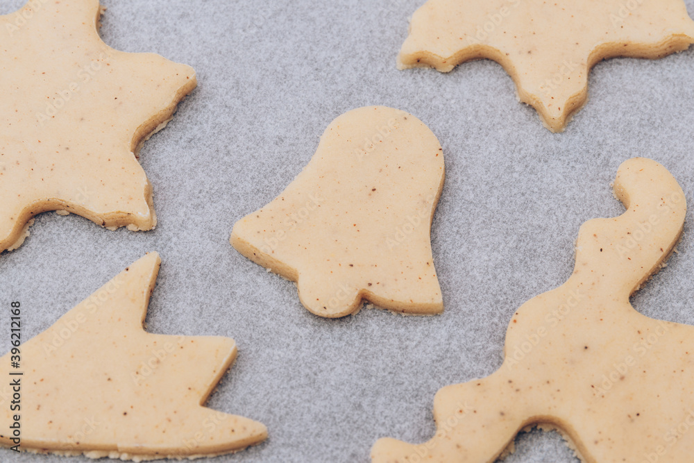 Raw gingerbread cookies on the white baking sheet. Raw gingerbread cookies on the white baking sheet.