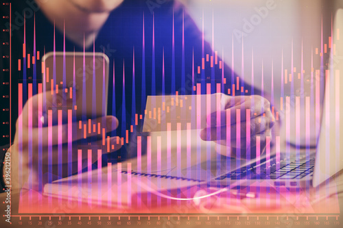 Double exposure of man's hands holding and using a phone and financial graph drawing. Analysis concept. © peshkova