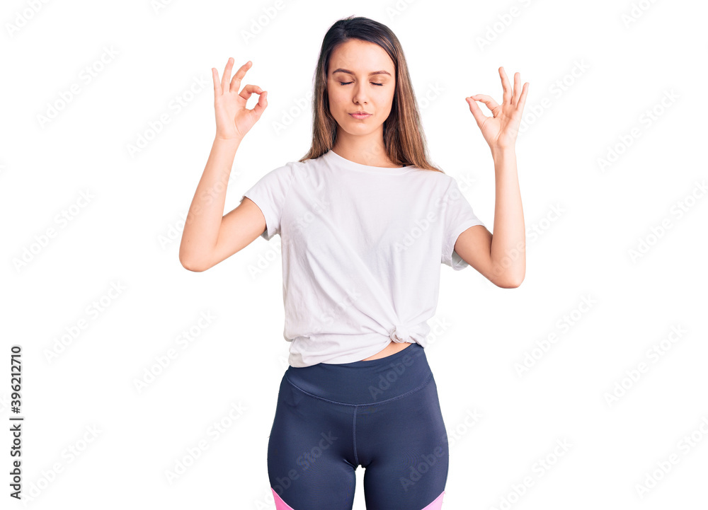Young beautiful girl wearing casual t shirt relax and smiling with eyes closed doing meditation gesture with fingers. yoga concept. Young beautiful girl wearing casual t shirt relax and smiling with eyes closed doing meditation gesture with fingers. yoga concept.