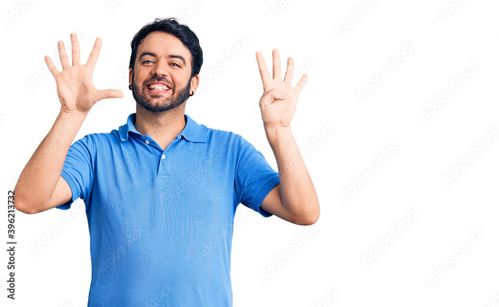 Fototapeta premium Young hispanic man wearing casual clothes showing and pointing up with fingers number nine while smiling confident and happy.