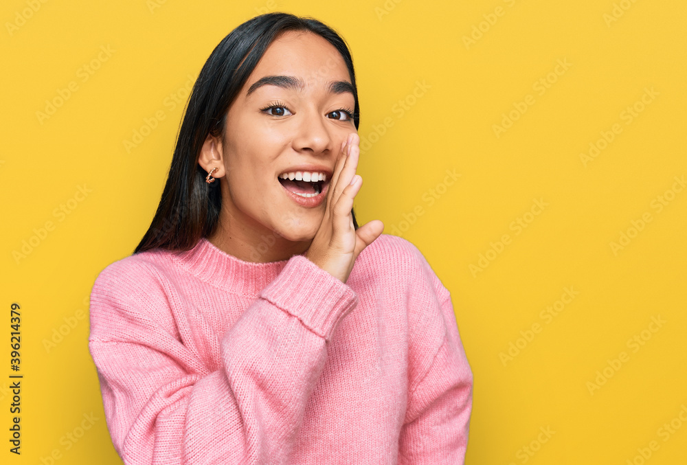 Young asian woman wearing casual winter sweater hand on mouth telling secret rumor, whispering malicious talk conversation Young asian woman wearing casual winter sweater hand on mouth telling secret rumor, whispering malicious talk conversation