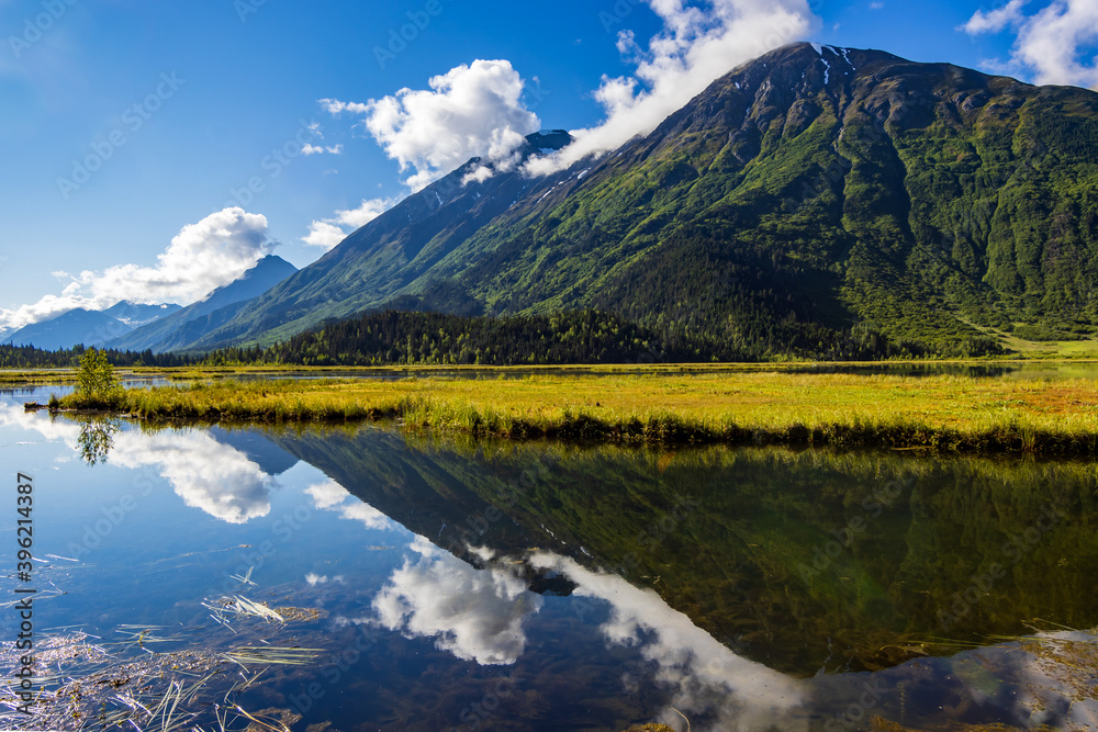 Wide angle landscape of Tern Lake in Summer on the  Kenai Peninsula, Moose Pass, Alaska with the mountains reflecting in the calm alpine lake on a sunny day