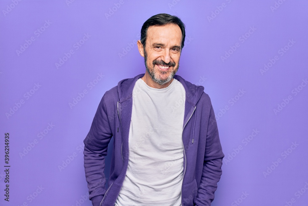 Fototapeta premium Middle age handsome sporty man wearing casual purple sweatshirt over isolated background with a happy and cool smile on face. Lucky person.