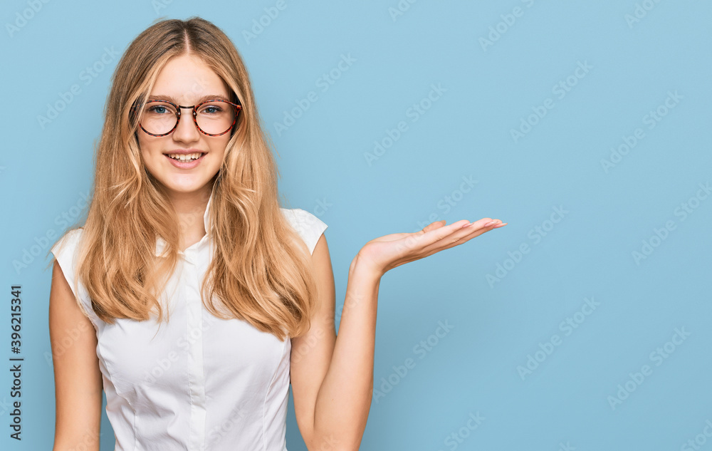 Fototapeta premium Beautiful young caucasian girl wearing casual clothes and glasses smiling cheerful presenting and pointing with palm of hand looking at the camera.