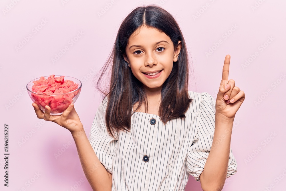Beautiful child girl holding ice cream smiling with an idea or question pointing finger with happy face, number one Beautiful child girl holding ice cream smiling with an idea or question pointing finger with happy face, number one