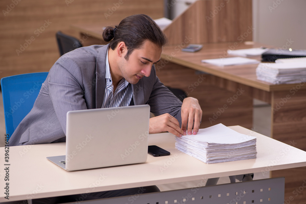 Young male employee working in the office Young male employee working in the office