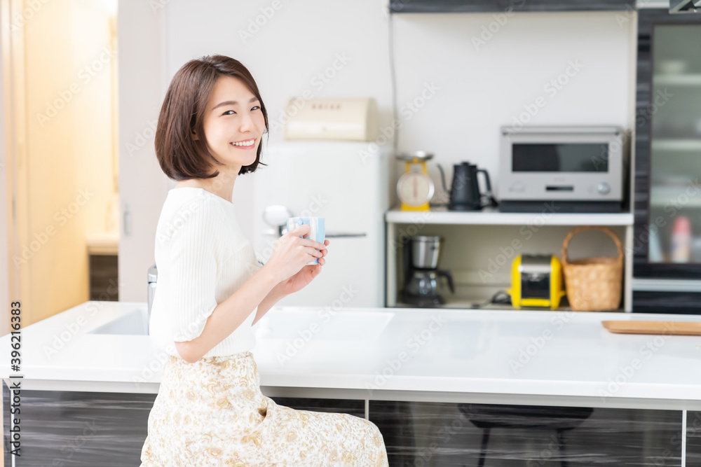 部屋で飲み物を飲む女性 部屋で飲み物を飲む女性