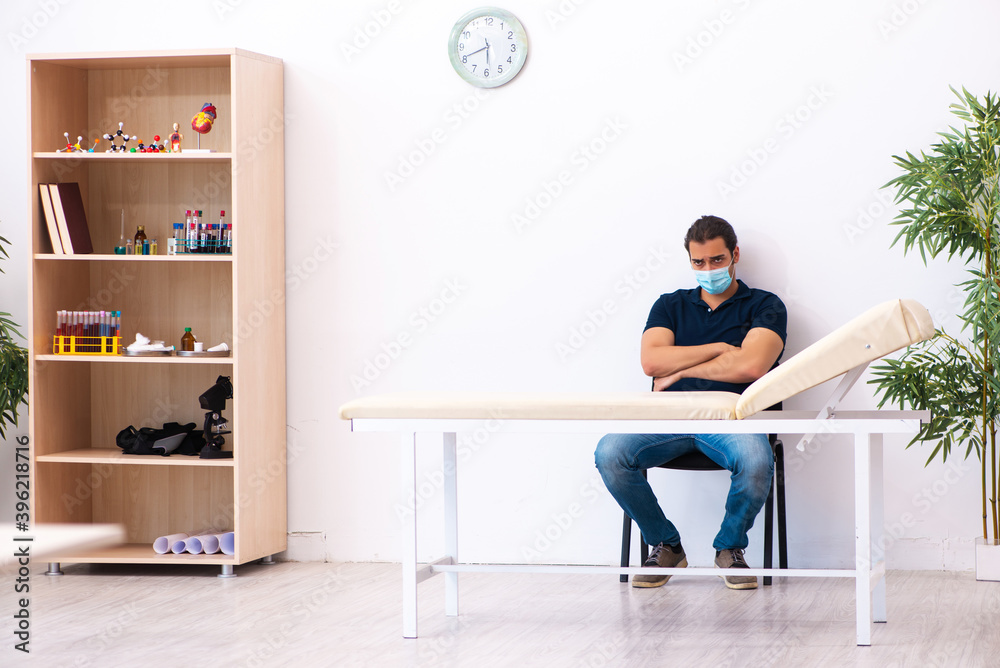Young man waiting for doctor during pandemic in hospital Young man waiting for doctor during pandemic in hospital