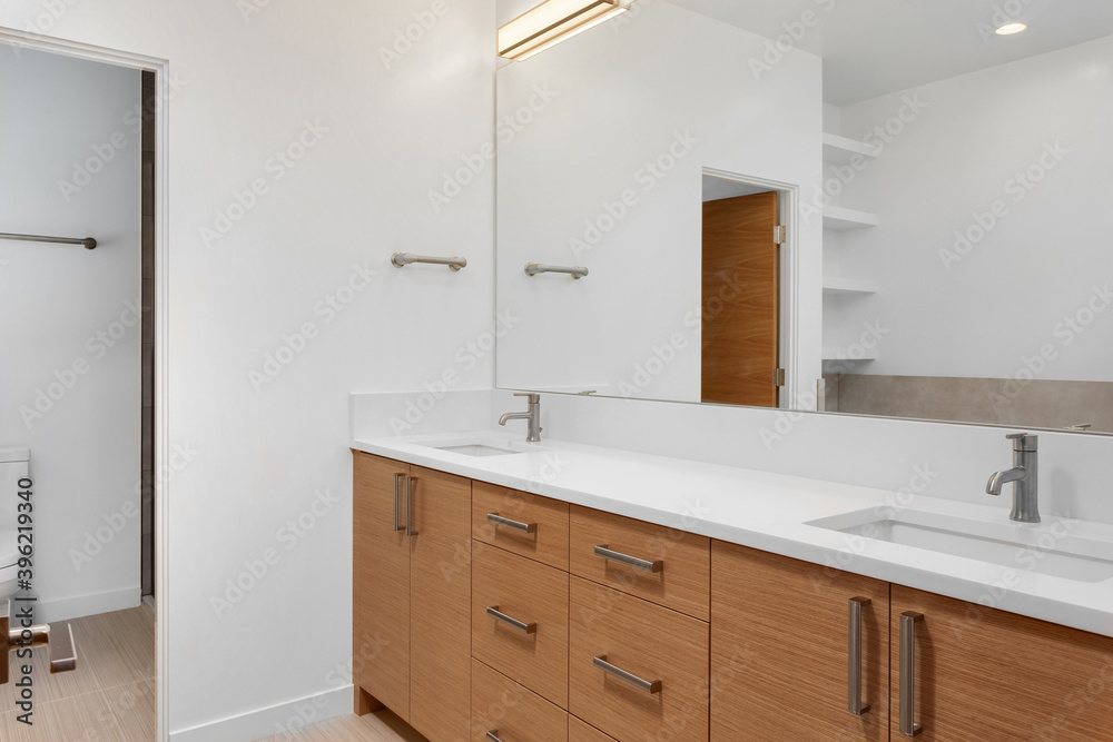 Bathroom in luxury home with double vanity, mirror, sink, and tile floor Bathroom in luxury home with double vanity, mirror, sink, and tile floor