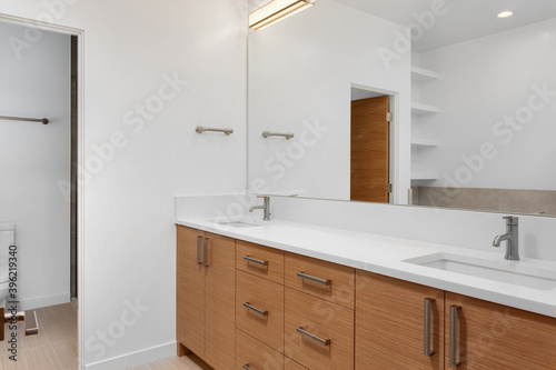 Bathroom in luxury home with double vanity, mirror, sink, and tile floor