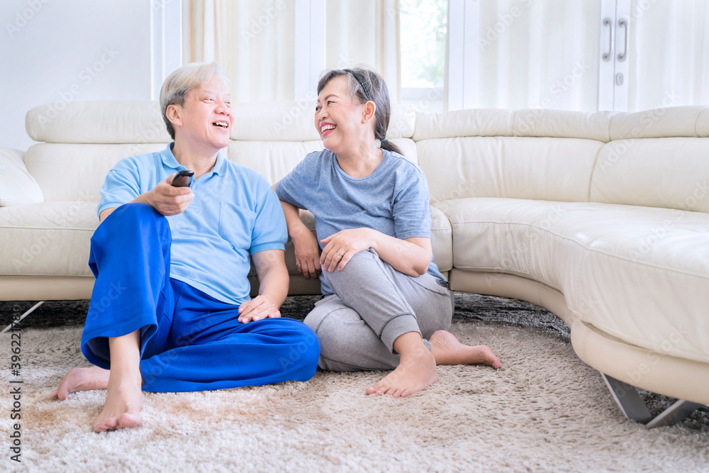 Happy elderly couple watching TV after exercise Happy elderly couple watching TV after exercise