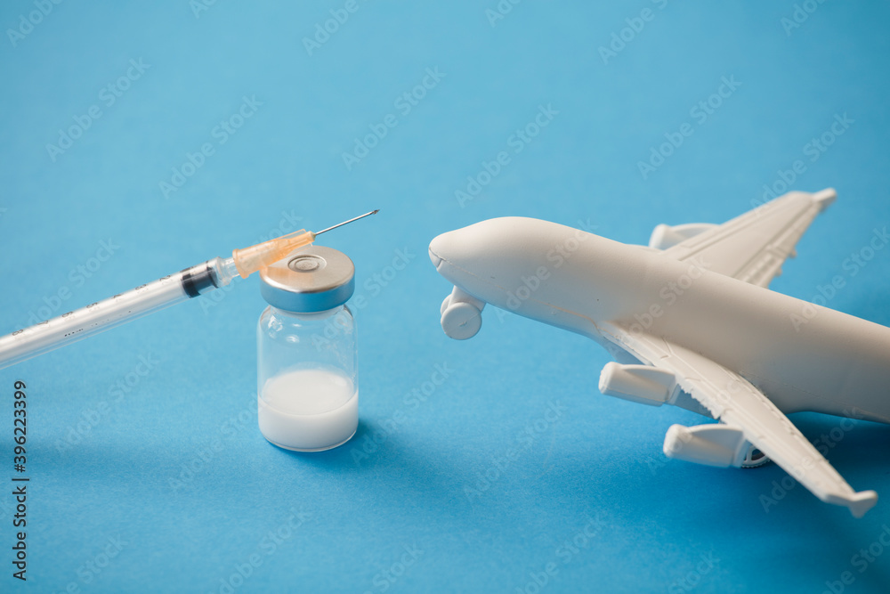 vaccine canister with syringe and white plane, blue background Stock Photo  | Adobe Stock