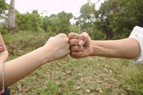 greeting with fist bump between people as a result of covi-19 maintaining distance