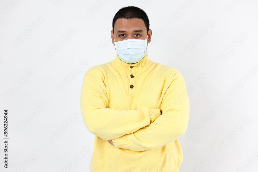 Asian man in a protective mask looking at camera on white background Asian man in a protective mask looking at camera on white background