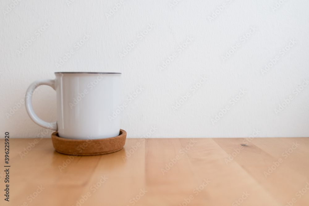 White hot coffee cup on wooden table and white wall with copy space. White hot coffee cup on wooden table and white wall with copy space.