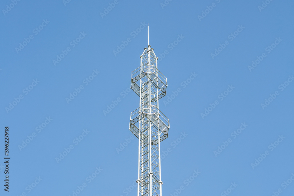 Phone antenna with sunlight on blue sky background Phone antenna with sunlight on blue sky background