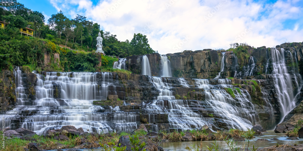 Fototapeta premium Waterfall early winter afternoon with water flowing over rocks and moving clouds creating spectacular beauty for the most beautiful water line highlands