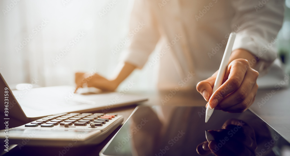 Fototapeta premium Hand of a business woman with a pen and a smartphone working on documents on the table in office.