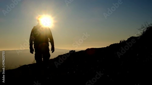 Silhouette of Man go hiking and look at the beautiful sunset view on mountain