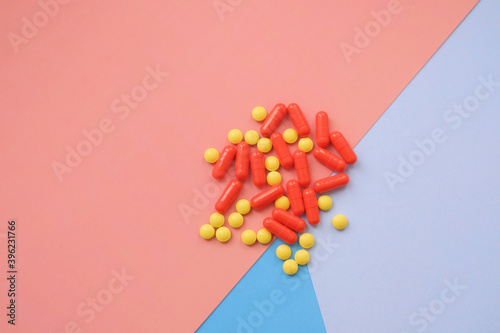 red and yellow different pills on multicolor table. A lot of colorful different pills including anti-viral drugs. Medicine and healthcare. Medications and Phramacy. photo