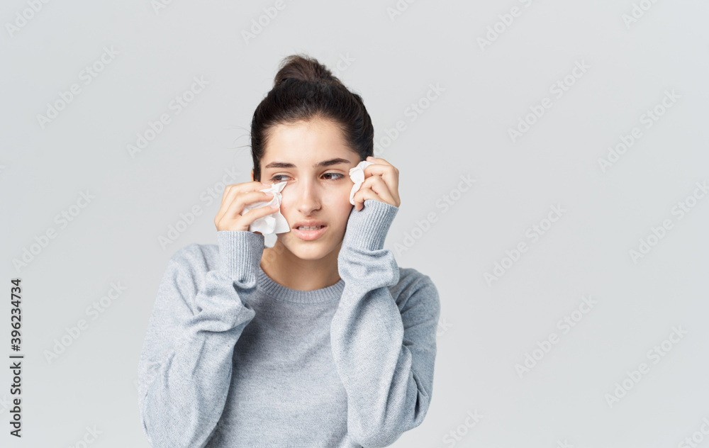 Woman runny nose health problems gray sweater napkin Woman runny nose health problems gray sweater napkin