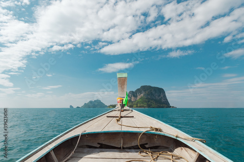 Traveling in Thailand. Amazing view from over Thai traditional wooden longtail boat travel on the sea tropical island with scenery of beautiful sea and sky.