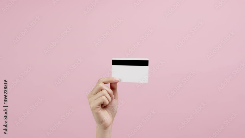 Hand holding credit cards and showing on the pink background. Hand holding credit cards and showing on the pink background.