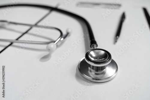 Stethoscope and writing pen lie on a paper holder